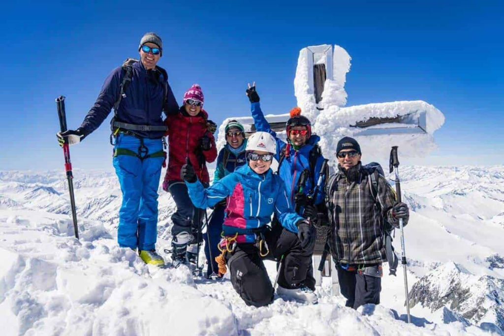 Gruppencollage von Skitourengehern auf einem Gipfel in den Alpen im Winter.